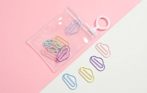 Detail of colorful cloud-shaped paperclips inside a transparent stationery pouch