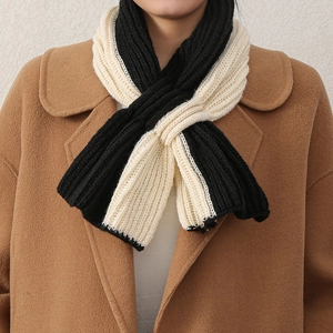 Détail d'une écharpe en maille bicolore noir et blanc portée par un mannequin chic