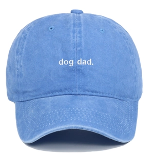 Detailed close-up of dog dad white embroidery on blue washed cotton baseball cap texture