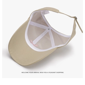Detail of khaki sun visor interior with pink bow embroidery and adjustable back strap