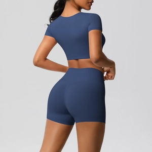 Seitenansicht des dunkelblauen Yoga-Sets mit kurzärmeligem Crop-Top und Sport-Shorts mit hohem Bund