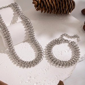 Vue détaillée de l'ensemble collier et bracelet en acier inoxydable argenté sur pierre
