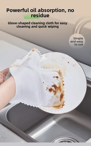 Detail of disposable cleaning glove wiping oil stains on a plate in kitchen sink