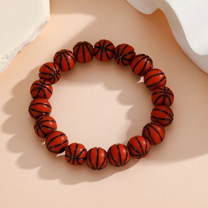 Detail of adjustable woven basketball beaded bracelet with textured orange resin beads