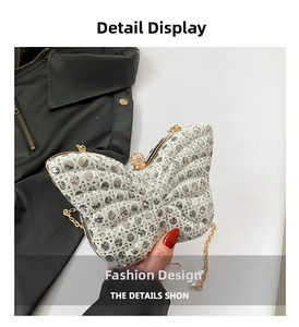 Détail de la pochette papillon argentée avec strass et bandoulière chaîne dorée