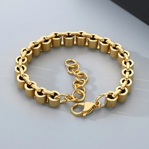 Detailansicht eines goldenen Zylinder-Gliederarmbands mit Karabiner und Verlängerungskette