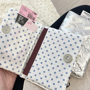 Detail of polka dot passport holder showing internal card slots and magnetic closure