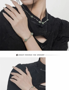 Detailed shot of silver bamboo-style bracelet with green aventurine stone on black outfit