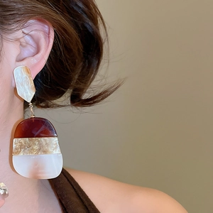 Detail of vintage French resin earrings featuring three-layer contrast marble texture