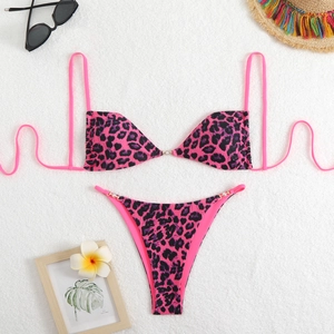 Pink leopard print bikini set with stylish bead details on a white plush background