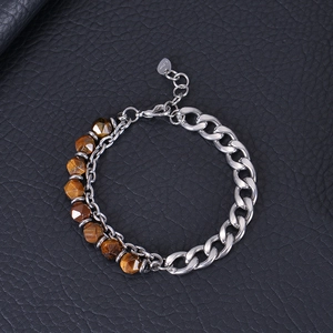 Detail of stainless steel Cuban chain and faceted tiger eye beads on black leather