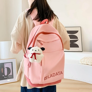 Dettaglio di uno zaino in nylon rosa con un grazioso portachiavi a forma di cagnolino