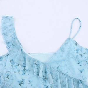 Detail view of light blue mesh top featuring irregular ruffles and floral print design