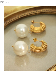 Macro shot of vintage pearl earrings with gold-plated textured base and white pearls