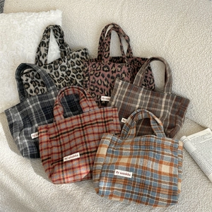 Group photo of plaid and leopard print wool tote bags on a sofa showing fabric textures