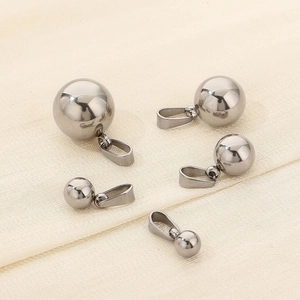 Polished stainless steel ball pendants in various sizes on minimalist fabric background