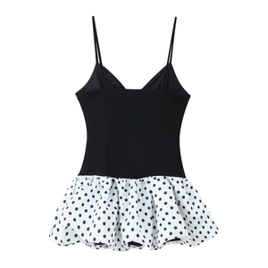 Detail of slim strap V-neck dress featuring black bodice and white polka dot skirt