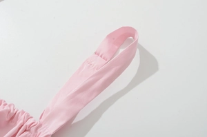 Detail of pink shoulder strap showing fine textile texture and stitching on dress