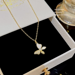Detailed close-up of a butterfly pendant necklace with white enamel and sparkling zircons