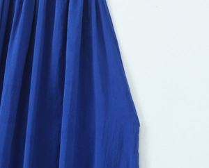 Detailed macro view of the royal blue pleated fabric texture and vertical folds