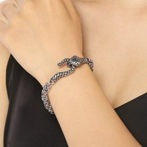 Vue détaillée du fermoir tête de serpent et de la texture d'écailles sur le bracelet
