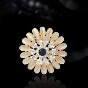 Elegant rotating sun flower brooch with opal petals and blue gemstone on black background