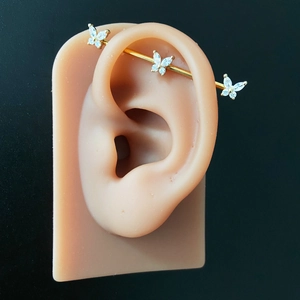 Golden butterfly industrial barbell piercing with white marquise zircon stones