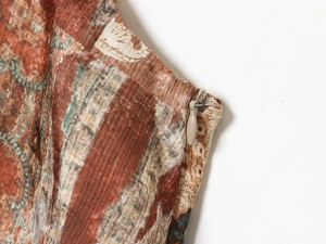 Détail de la fermeture éclair invisible et du tissu en satin sur la mini robe imprimée