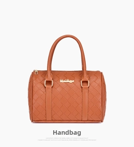 Close-up of brown woven texture handbag with light gold hardware and double handles