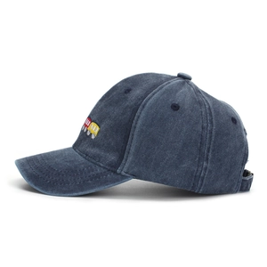 Detail of red and yellow train embroidery on navy washed denim kids baseball cap