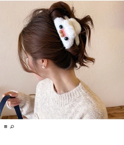 Detailed view of soft plush white hair claw clip with cute cartoon face on model