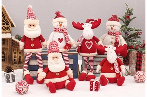 Group of plush Christmas figurines with knitted details displayed in a festive scene