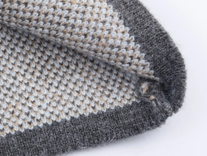 Detailed macro view of high-quality tri-color jacquard knit texture in grey and blue