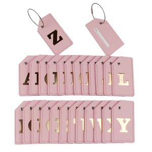 Detail view of pink PU leather luggage tags with gold letters and metal wire ring connectors