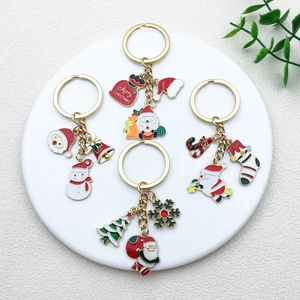 Detailed flat lay of Christmas keychains with Santa and tree charms on a white tray