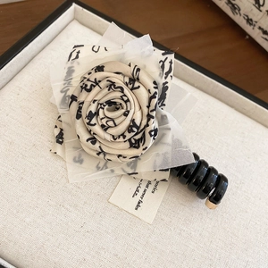 Sweet floral telephone wire hair tie with artistic fabric rose design for daily wear.