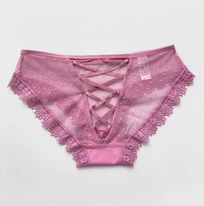 Gros plan sur une culotte en dentelle rose avec lanières croisées et texture résille