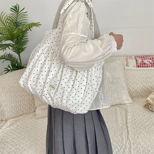 Detailansicht der weißen Polka-Dot Segeltuchtasche mit Faltenoptik und Markenlabel
