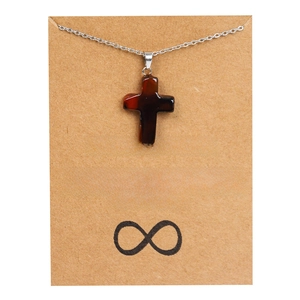 Pendentif croix en pierre sur chaîne argentée présenté sur une carte d'amitié
