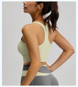 Vue latérale d'un haut de sport vert et legging gris extensible pour yoga et entraînement