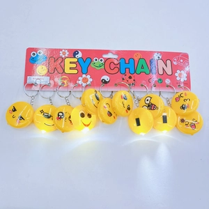 Set of 12 yellow emoji LED keychains with different expressions on a display card