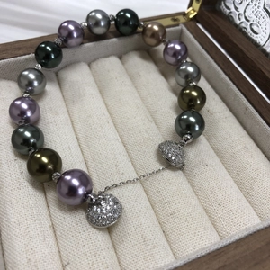 Detailed macro view of multicolor pearls and silver diamond pendant in a luxury jewelry box