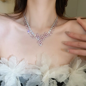 Dettaglio della collana con fiori di zircone rosa indossata sul collo di una modella