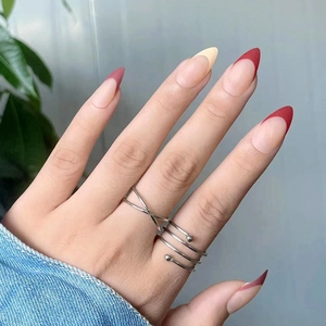 Matte almond-shaped French press-on nails with nude base and deep red tips
