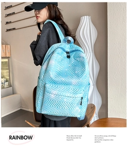 Mochila acolchada azul claro con estampado de corazones llevada por modelo en café