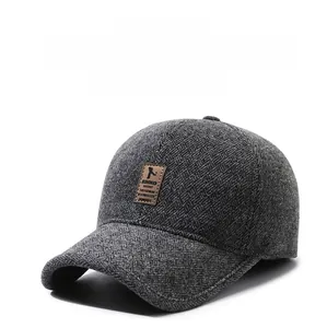 Detailed view of grey herringbone baseball cap with brown leather brand patch