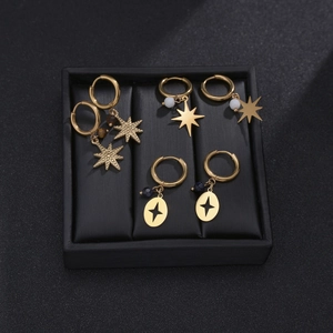 Détail de boucles d'oreilles créoles plaquées or 14K avec breloques d'étoile et perles