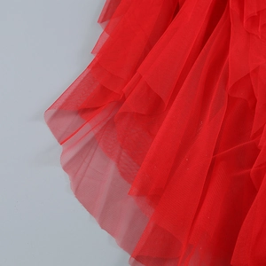 Vue détaillée de la texture du tissu en tulle rouge multicouche avec des volants