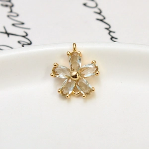 Macro view of gold flower pendant with zircons and dual connection loops for DIY jewelry