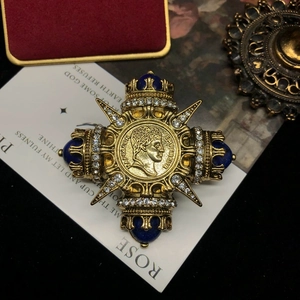 Macro detail of vintage gold Napoleon brooch featuring lapis lazuli and white crystals